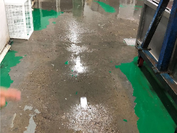 Старый эпоксидный заводской пол с обширными пятнами от пролитых химикатов, масел и грязи, которые проникли сквозь разрушенное покрытие.