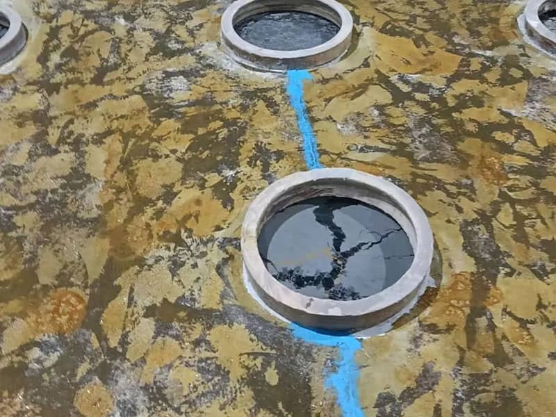 Degraded concrete floor in a food pickling room, with severe dusting and liquid penetration, posing a hygiene risk before polyurethane mortar overlay.