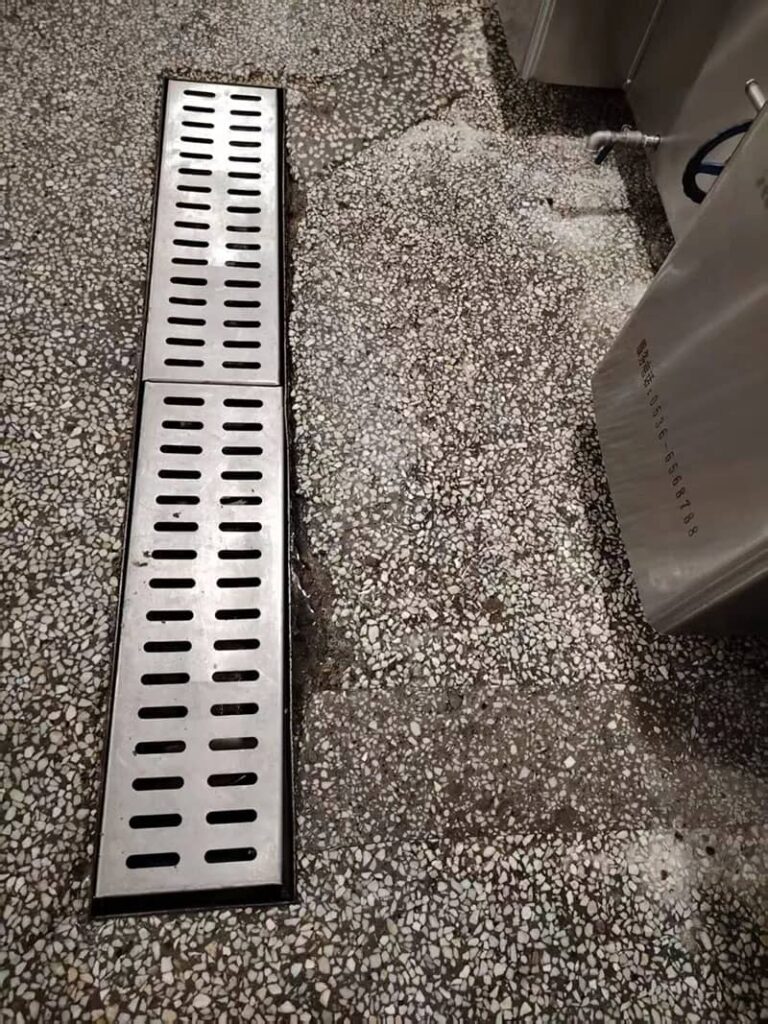 Terrazzo floor surface damaged by chemical corrosion from seasonings and cleaners, with visible peeling and uneven areas.