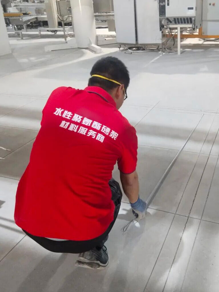 A KAIDA JINYU engineer measures the layout and positioning of anchorage slots on the concrete base prior to cutting, ensuring optimal stress distribution for the flooring system.
