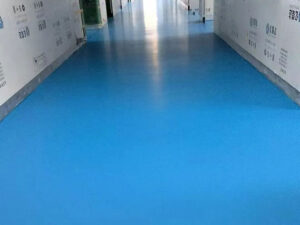 A wide-angle view of a modern GMP pharmaceutical cleanroom featuring a seamless, light-colored KAIDA PAINT urethane mortar floor, demonstrating a sterile environment for drug manufacturing.