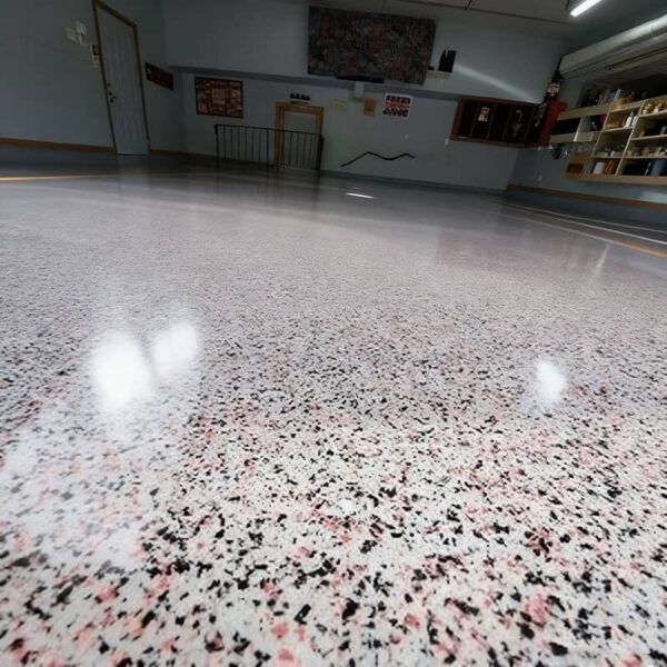Close-up view of DIY epoxy garage floor coating showing flake distribution and smooth, durable aliphatic urethane topcoat finish