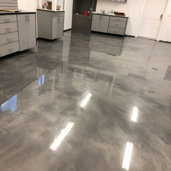 Durable metallic epoxy floor coating in commercial setting, featuring anti-skid top coat protection and chemical resistance for heavy-duty use.