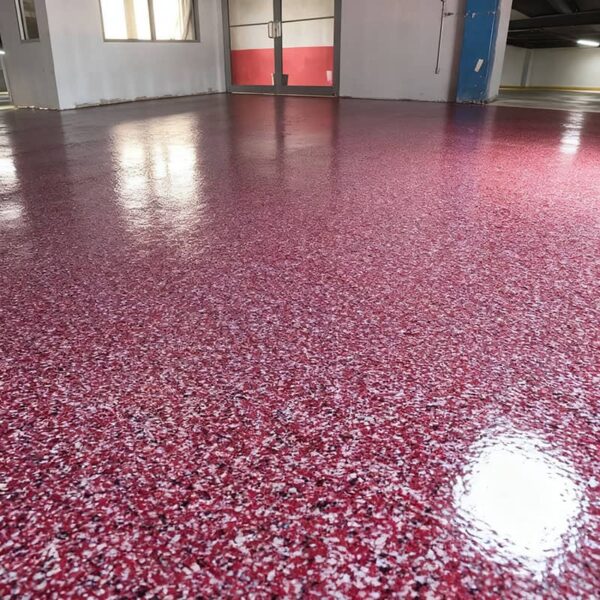 Close-up of our professional epoxy flake garage floor showing deep 3D texture and high-gloss, UV-resistant urethane topcoat.
