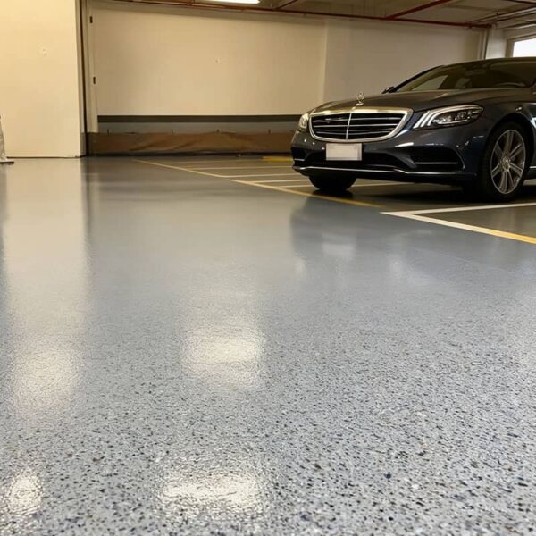 A sleek, high-gloss finish of a polyurea garage floor in a modern garage, showcasing a seamless and reflective surface.