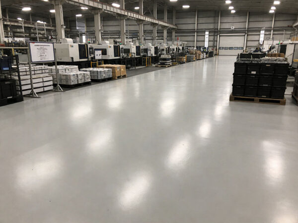Ure-Crete MD cementitious urethane flooring in a manufacturing area: self-leveling matte system with thermal shock resistance, ideal for heavy-equipment production spaces.