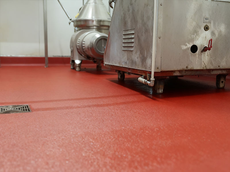 Red food-grade flooring in dairy factory: Completed by Kaida Contractor, this seamless surface delivers excellent slip resistance