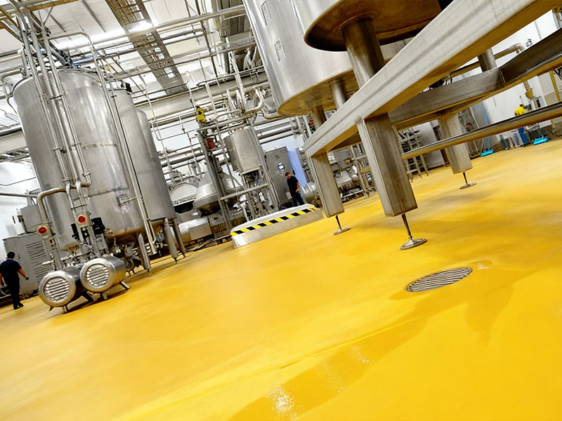 Yellow seamless industrial flooring in dairy factory: Slip-resistant, stain-proof, easy-to-clean, wear-resistant (for heavy equipment), chemical-resistant (to dairy/cleaners), and hygienic (food-safety compliant).