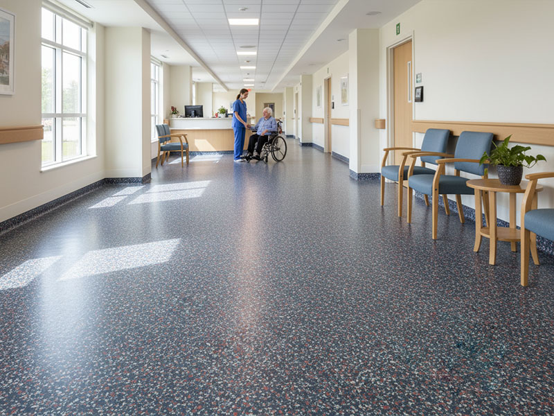 ResuField Deco Flake BC decorative mosaic pattern flooring with vinyl chips and a high-gloss finish installed in a bright healthcare facility hallway.