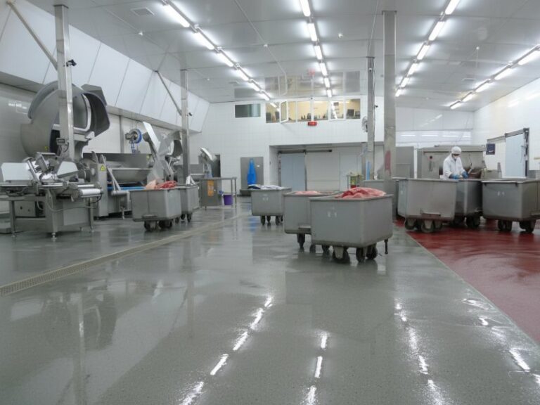 Durable and sanitary meat, poultry, and fish processing facility floor featuring a seamless, slip-resistant resinous coating designed for wet environments and heavy cart traffic.