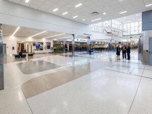 High-gloss KAIDA PAINT epoxy flooring in a modern stadium concourse area, reflecting light and showcasing a pristine finish