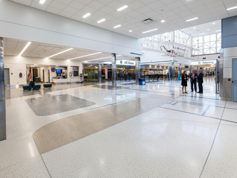 High-gloss KAIDA PAINT epoxy flooring in a modern stadium concourse area, reflecting light and showcasing a pristine finish