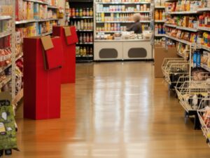 A clean and highly reflective supermarket aisle showcasing durable resinous floor coating by KAIDA PAINT, designed for heavy foot traffic and easy maintenance.
