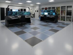 A modern network operations center (NOC) featuring multi-monitor control room consoles, ergonomic workstations, and server racks in a secure monitoring facility.