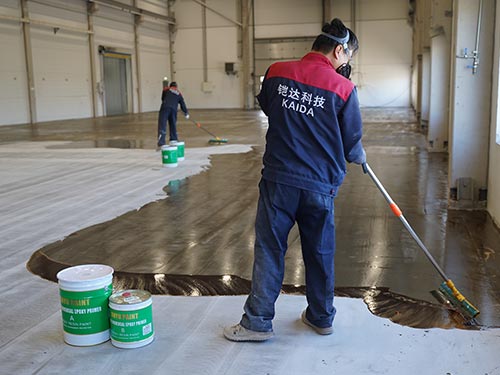 Spreading the epoxy mid-coat resin to build system thickness at a large-scale Swedish factory renovation site.