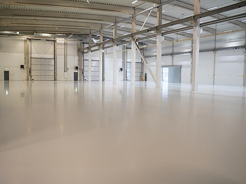 Wide-angle view of the completed 7,000 sqm factory floor in Sweden, featuring a bright, durable, and clean epoxy system.