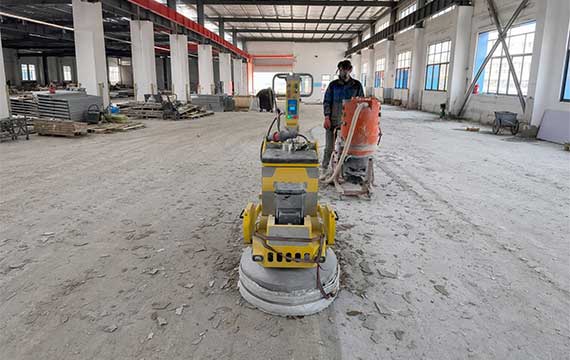 Concrete floor grinding during surface preparation for a Hungary battery plant epoxy flooring renovation project
