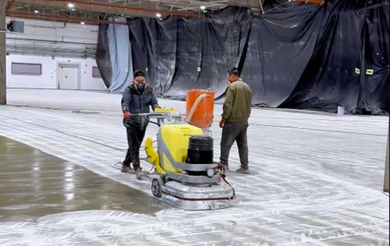 Intermediate coating sanding during epoxy flooring installation at a Hungary battery manufacturing facility