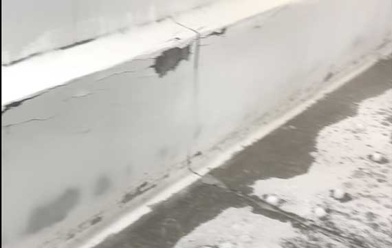 Extreme conditions: Iced-over wall-to-floor junction with visible cracks, demonstrating the need for thermal-shock resistant coving in cold storage.
