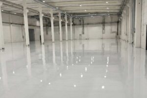 High-gloss industrial epoxy floor coating with water-based PU topcoat in a Sweden building materials processing plant renovation.