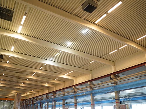 Large-scale factory ceiling renovation in Sweden, showing a bright, modernized roof structure with professional industrial coatings.
