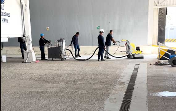 Professional flooring crew performing diamond grinding and joint cutting at a large-scale shrimp factory in Venezuela.