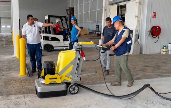 Industrial floor grinding and surface preparation using specialized machinery at a sea shrimp processing factory in Maracaibo, Venezuela.