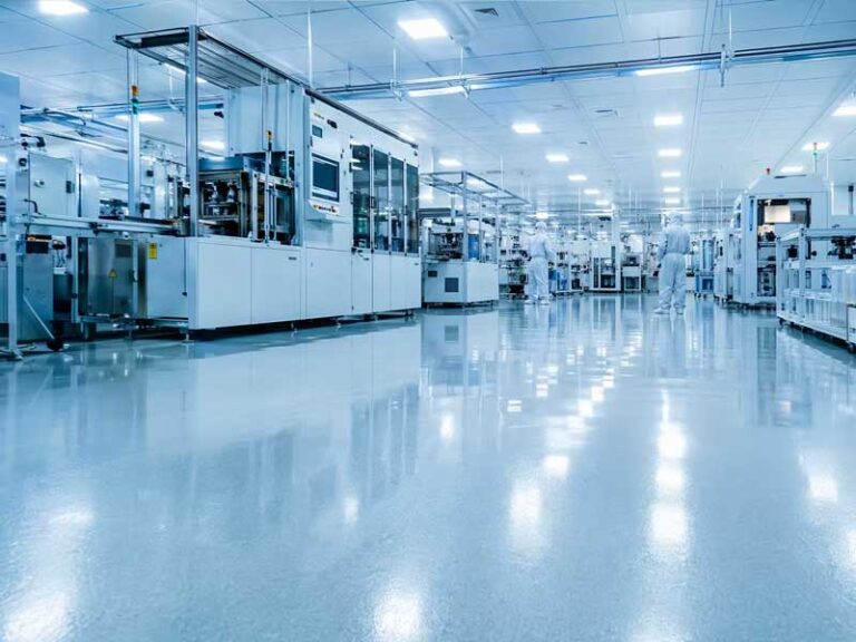 Premium architectural photography of a semiconductor cleanroom with a seamless conductive ESD epoxy floor and automated production equipment.