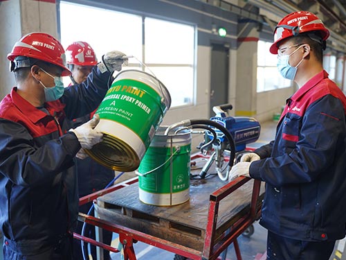 Professional workers mixing high-performance epoxy primer for a 7,000 sqm industrial flooring project in Sweden.