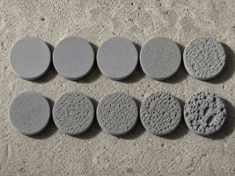 Set of ten ICRI CSP comparator chips from CSP 1 to CSP 10 resting on a prepared concrete floor