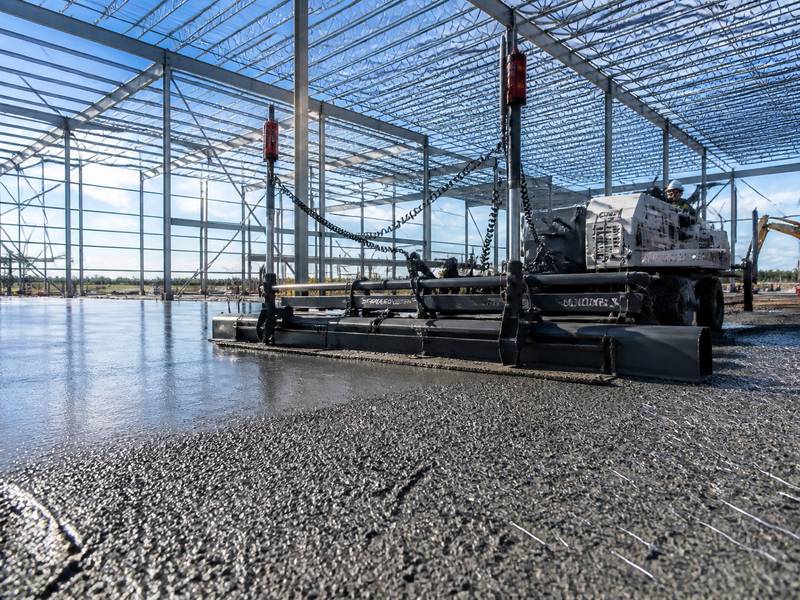 Construction of a jointless SFRC warehouse floor slab using a professional laser screed machine for ultra-flatness.